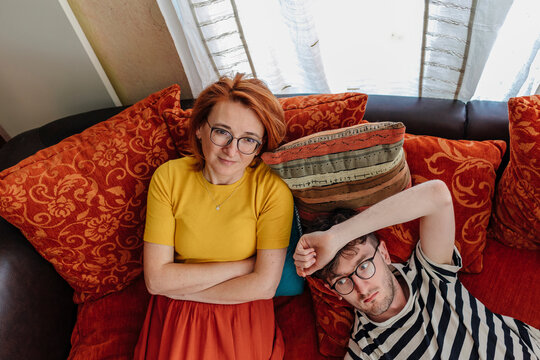 Thoughtful mother and son relaxing on sofa at home