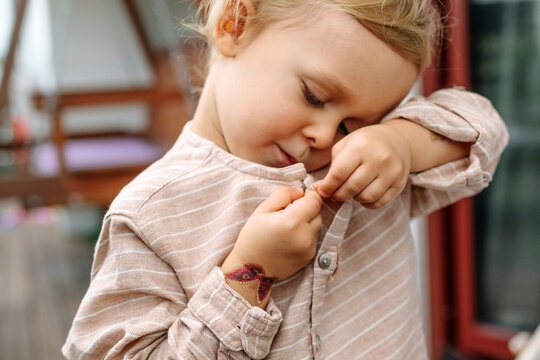 Close up of little boy who buttons his shirt