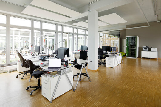 Laptop and computers on desk in empty office