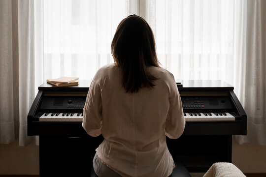 Young woman playing piano at home