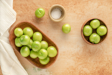 fresh ripe green plum fruits and salt on table