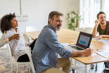 Multi-ethnic entrepreneurs discussing strategy in board room during meeting at office