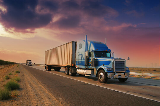Freight truck driving on highway desert road at sunset. California, USA