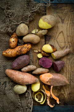 Different types of potatoes: Glorietta, purple sweet potato, Agria, Annabelle, Bamberger Hoerndl, Gala on rustic&not;&dagger;background