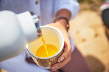 Woman's hands pouring orange juice in glass