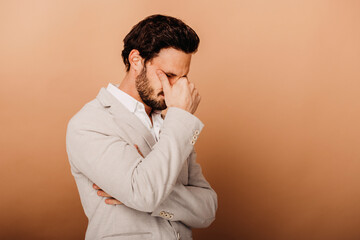 Frustrated businessman standing by brown background