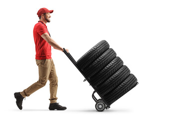 Full length profile shot of a worker pushing a hand truck with tires