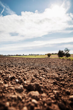 Freshly plowed agricultural field against sky