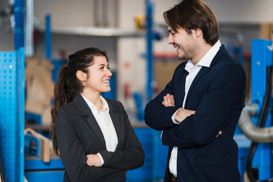 Young business people smiling while standing at industry
