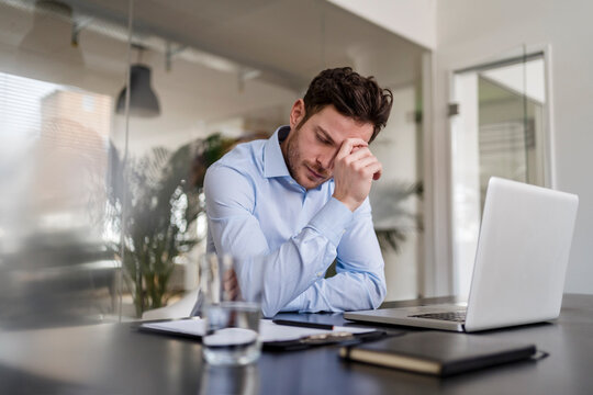 Tired businessman at desk in office