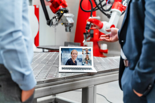 Male engineers discussing during video conference through laptop in industry