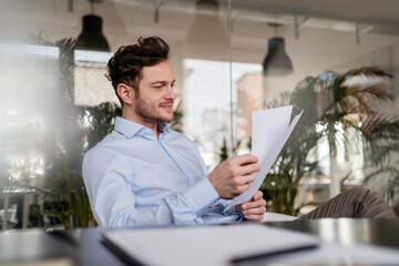 Businessman analyzing document while working at office