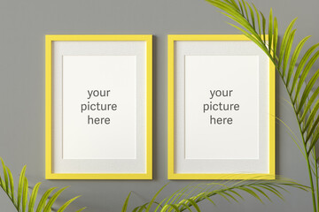 Three dimensional render of two picture frames with placeholder text hanging on gray wall