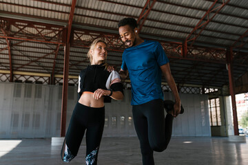 Male and female athletes doing warm up exercise in health club