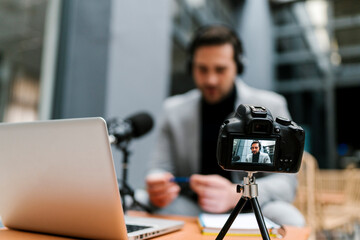 Businessman filming vlog through camera while sitting at cafe