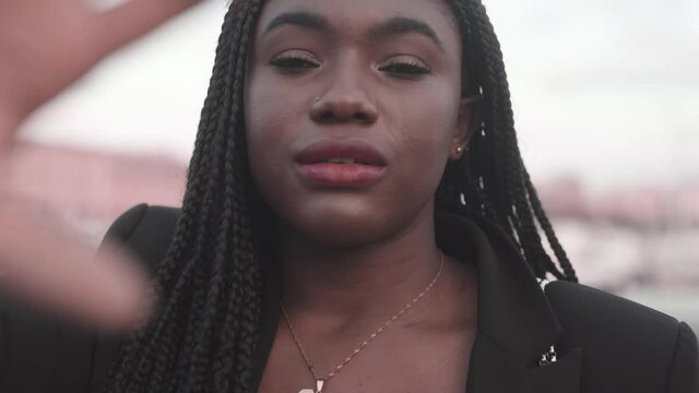 Crop charming black woman with Afro braids on city street