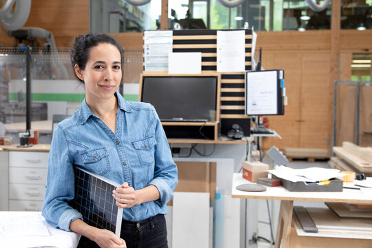 Businesswoman with solar panel model in factory