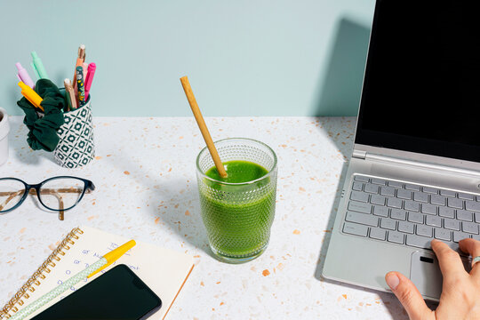 Woman's hand typing on laptop over desk at home