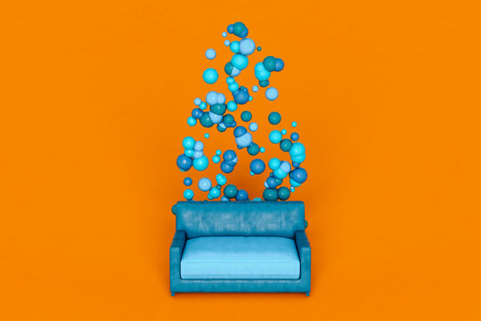 Blue spheres and sofa against orange background