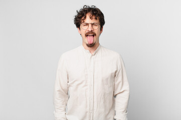 young handsome man with cheerful and rebellious attitude, joking and sticking tongue out