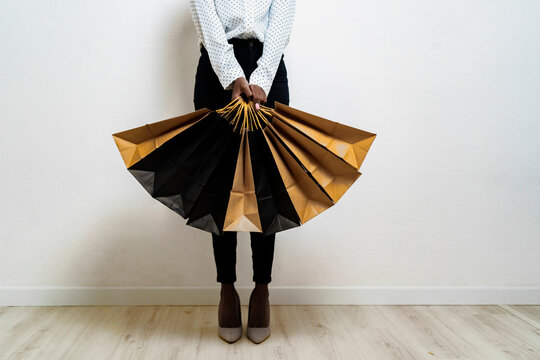 Young woman carrying shopping bags while standing against white background