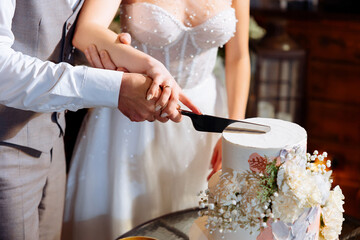 Cutting a wedding cake. Wedding traditions and rituals.