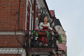 Fototapeta na wymiar Urban sculpture. Woman on the balcony.