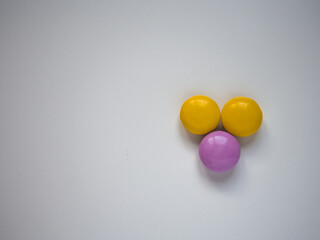 Top view of yellow and purple chocolate candy with copy space.