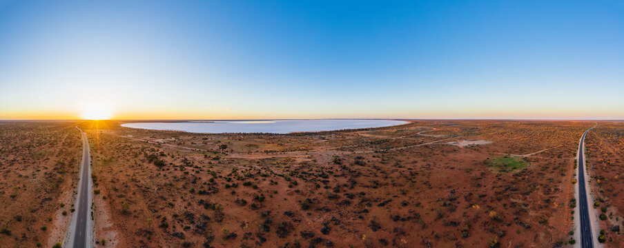 Australia, South Australia, Aerial view of Stuart Highway and salt lake in Lake Hart Area at sunset