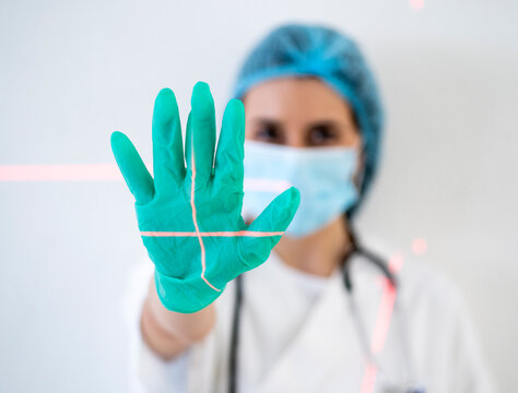 Female doctor's hand protecting face from laser light at clinic