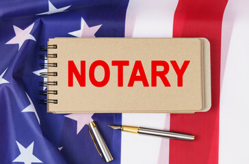 Against the background of the flag of the USA lies a notebook with the inscription - NOTARY