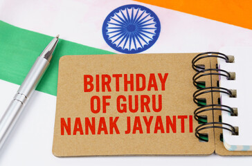 Against the background of the flag of India lies cardboard with the inscription - Birthday of Guru...