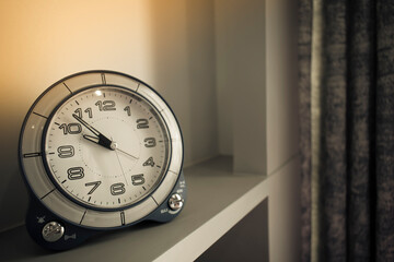 Close-up image of a clock set on a table and decorated in a vintage style.