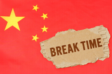 Fototapeta premium Against the background of the Chinese flag lies cardboard with the inscription - Break Time