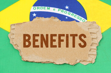 Against the background of the flag of Brazil lies cardboard with the inscription - BENEFITS