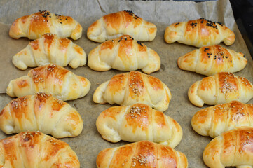 Homemade  Serbian dinner rolls( kiflice) withe sesame  on the backing sheet