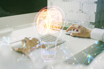 Creative idea concept with light bulb and human brain illustration and with hands typing on laptop on background. Neural networks and machine learning concept. Multiexposure