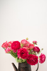 Fresh ranunculus and tulip bouquet in a vase with copy space