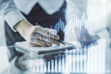 Abstract creative financial graph with hand writing in notebook on background, forex and investment...