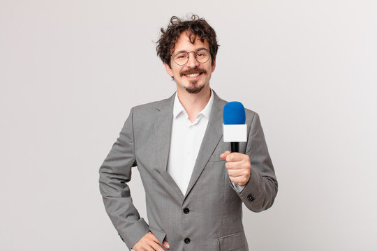 young man journalist smiling happily with a hand on hip and confident
