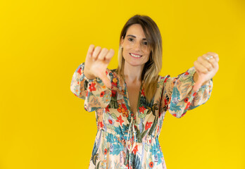 Young woman over isolated yellow background showing thumbs down.