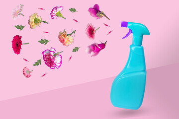 Creative minimal idea made from a blue bottle with a spray and various flowers flying in the air.