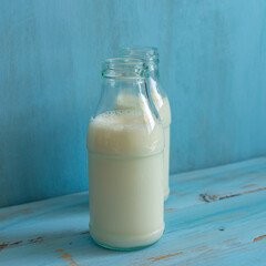 Milk bottle on blue wooden background. Ingredients for cooking. Dairy products.