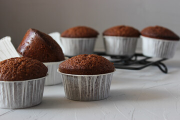 Chocolate muffins in paper forms on a gray background