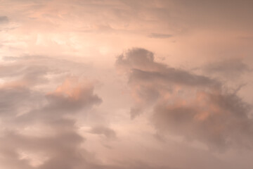 Fototapeta na wymiar Bright pink orange cloudy sky shot from above after the rain at sunset with a light from the sun on the left side of the frame above the level of clouds in soft colors and tones. High quality photo
