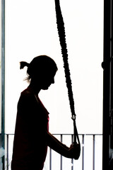 woman trains at home.fitness, gym, stretching, weights. keep fit at home. silhouette