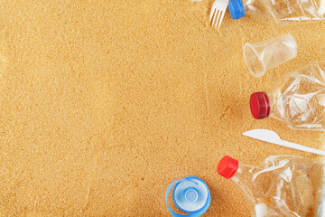 Fototapeta na wymiar Plastic trash on a sandy beach with Trash from plastic bottles on a sandy beach with free space.