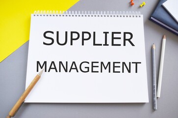 Supplier management memo written on a notebook with pencils, Conceptual business photo