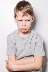 Obraz premium a blond boy has emotions on his face in the form of resentment and anger on a white background