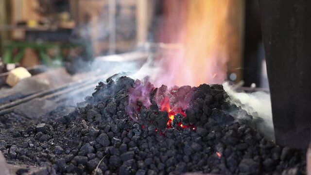 Coal forge fire in blacksmith shop with smoke and sparks